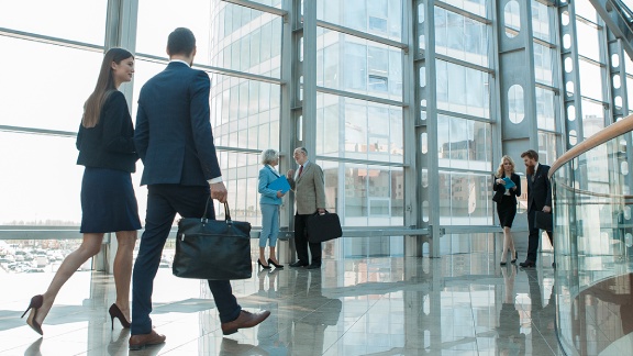 View of employees having the casual discussion and walking in the corridor 